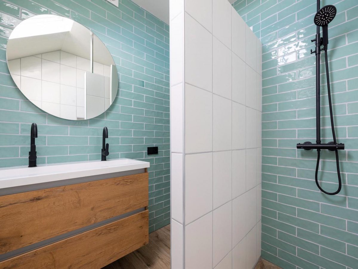 De badkamer met dubbele wastafel en regendouche